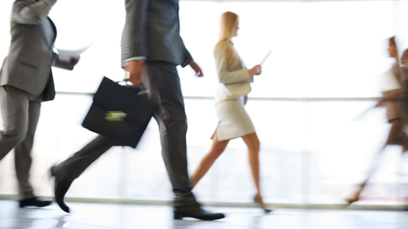 legs of people in business attire walking quickly