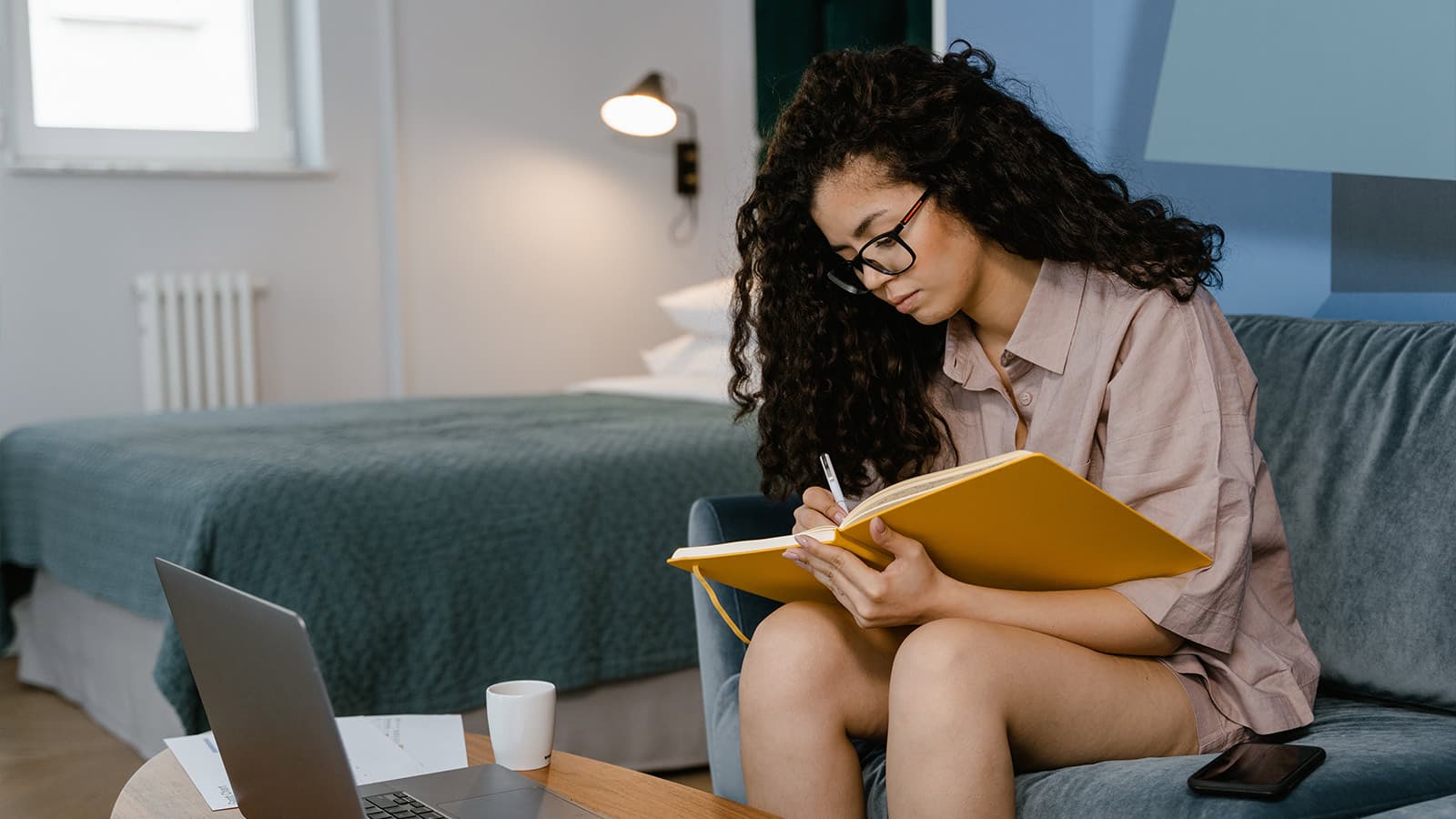 :Lady with laptop and notebook figuring finances