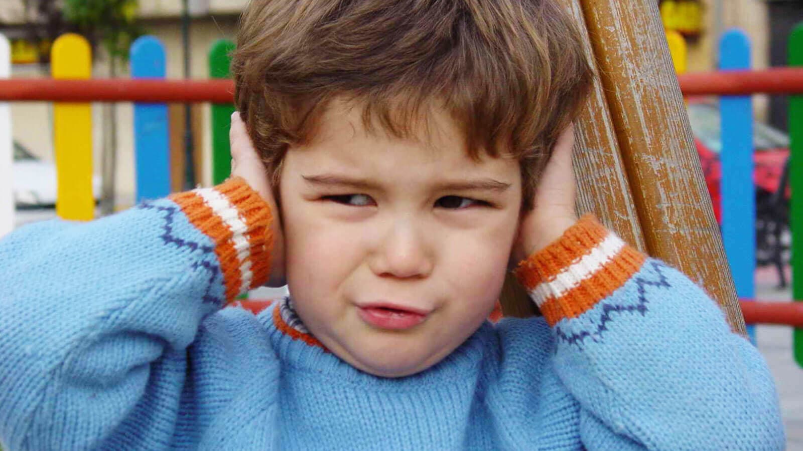 Little boy covering his ears