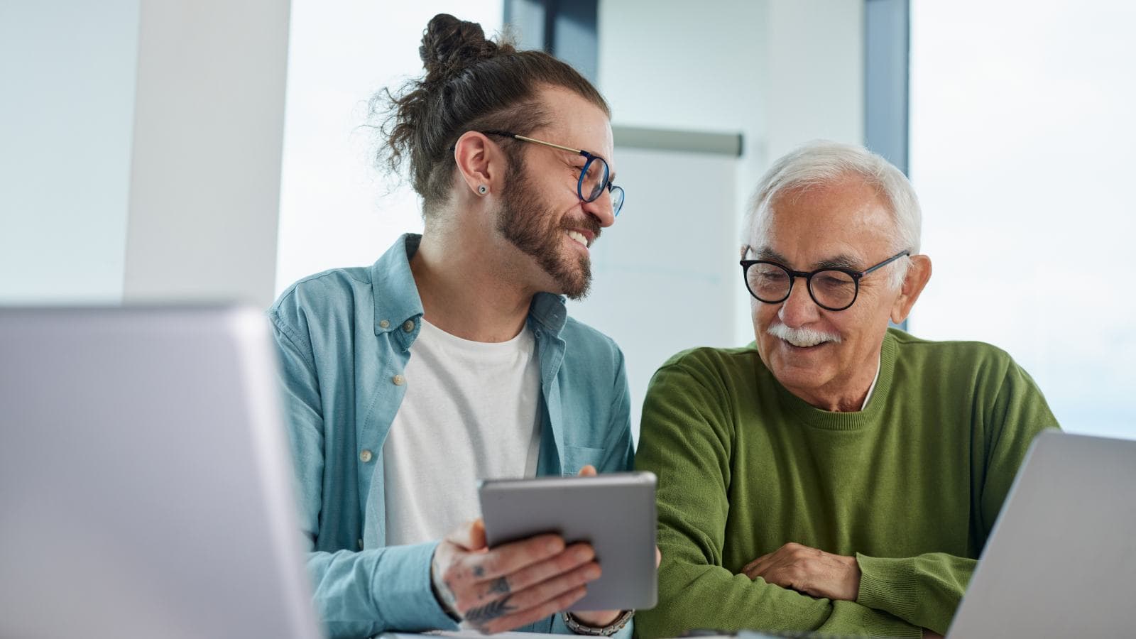 Two men together smiling at tablet computer