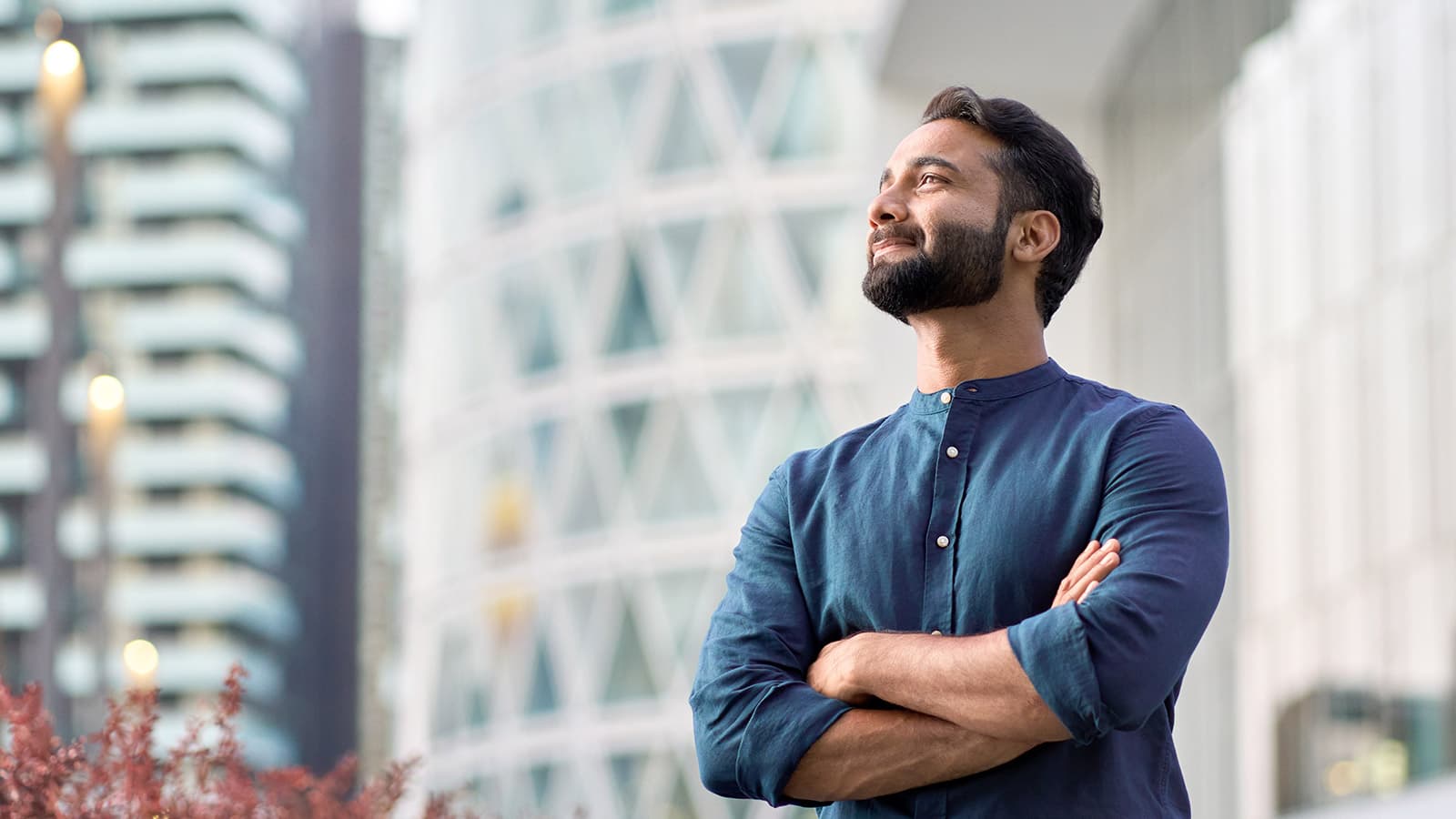 Man outside with arms folded, looking to future