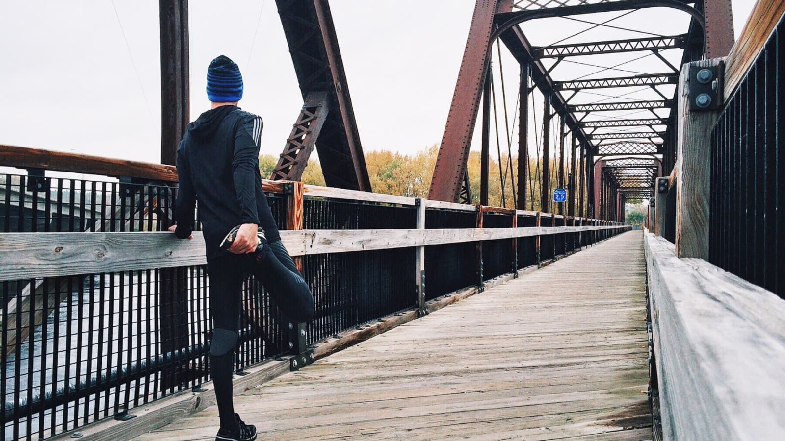 Man about to jog over a bridge