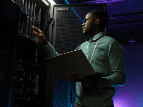 Man holding laptop in server room