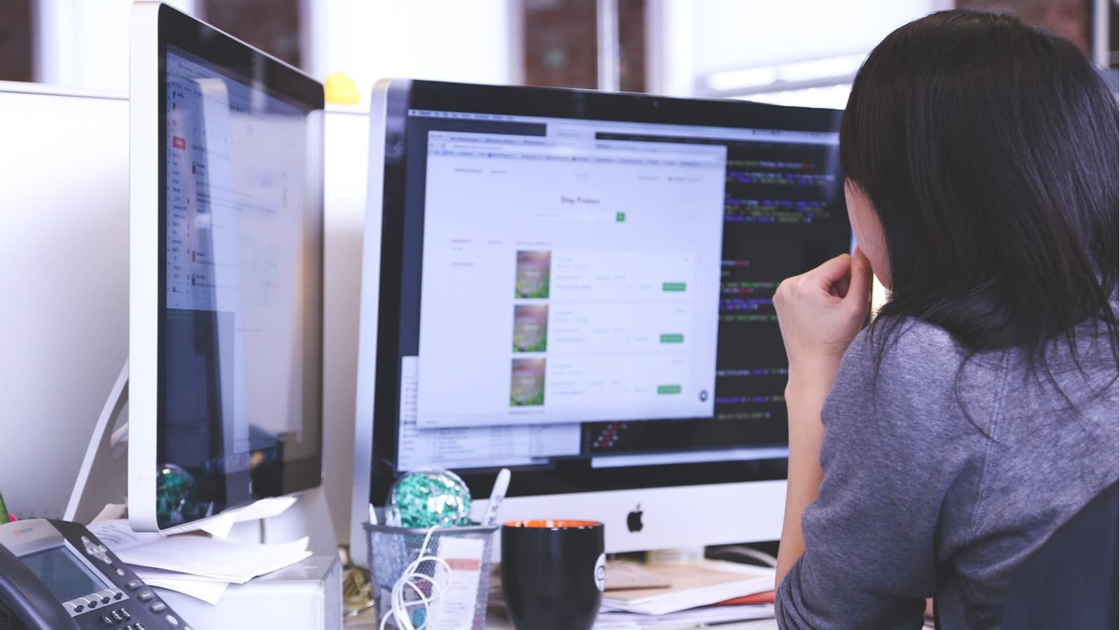 Woman working on 2 computer screens