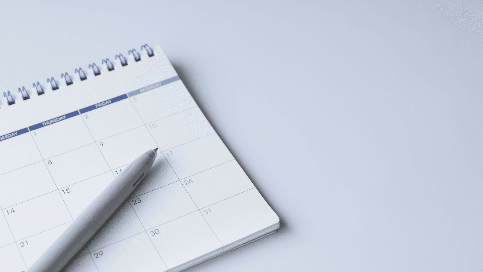 Corner of calendar with pen lying across it