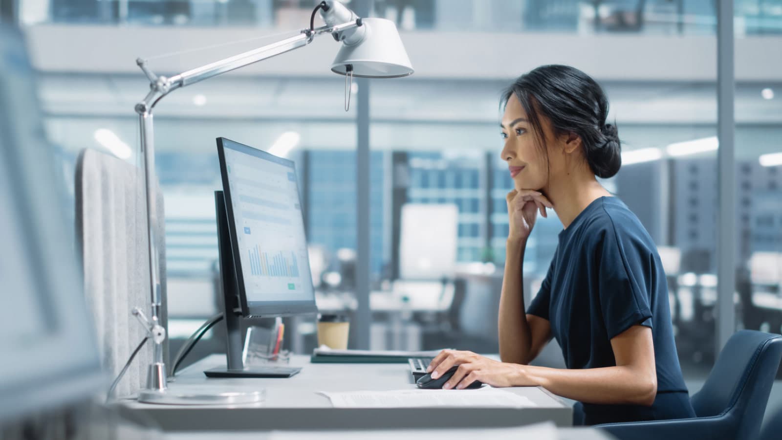 Woman looking at screen with anglepoise lamp over