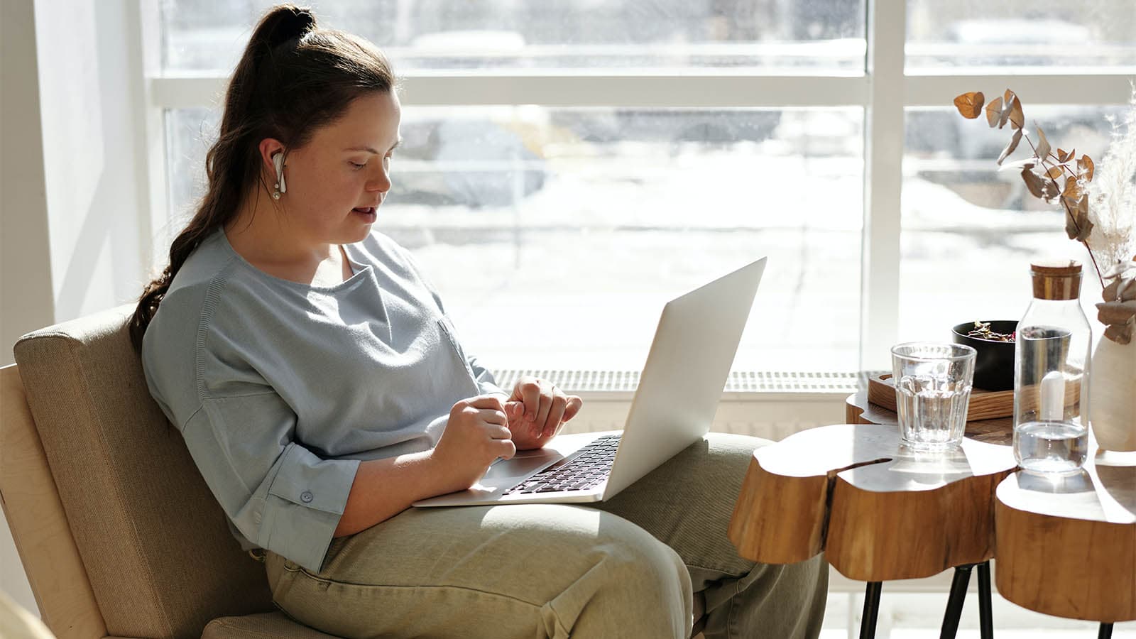 Girl on comfy chair with laptop on her lap
