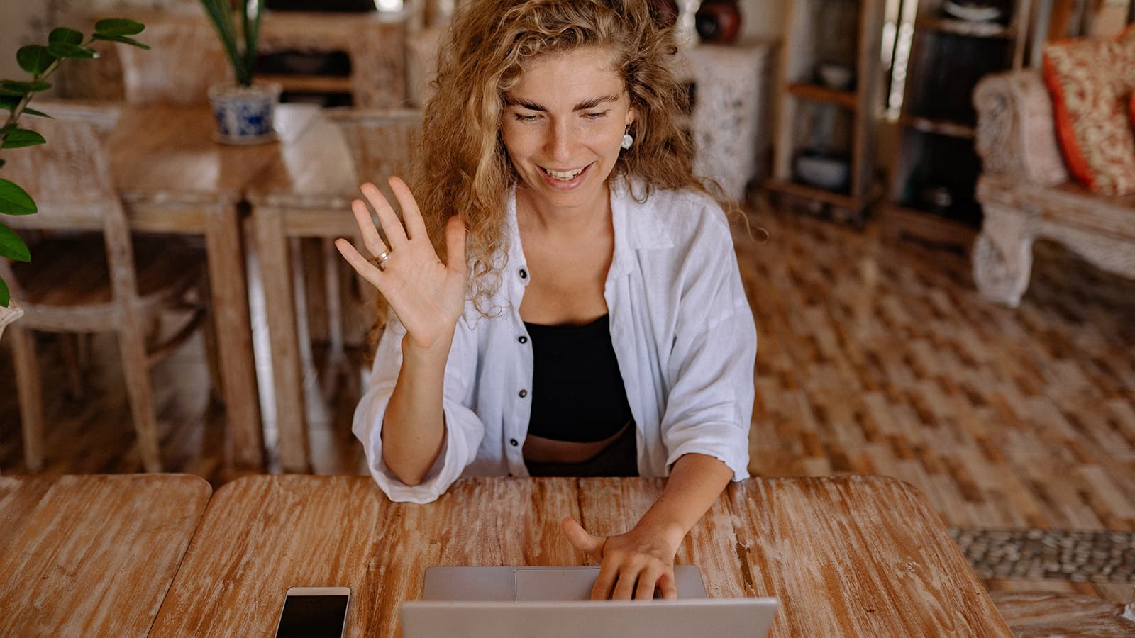 Woman waving at her laptop