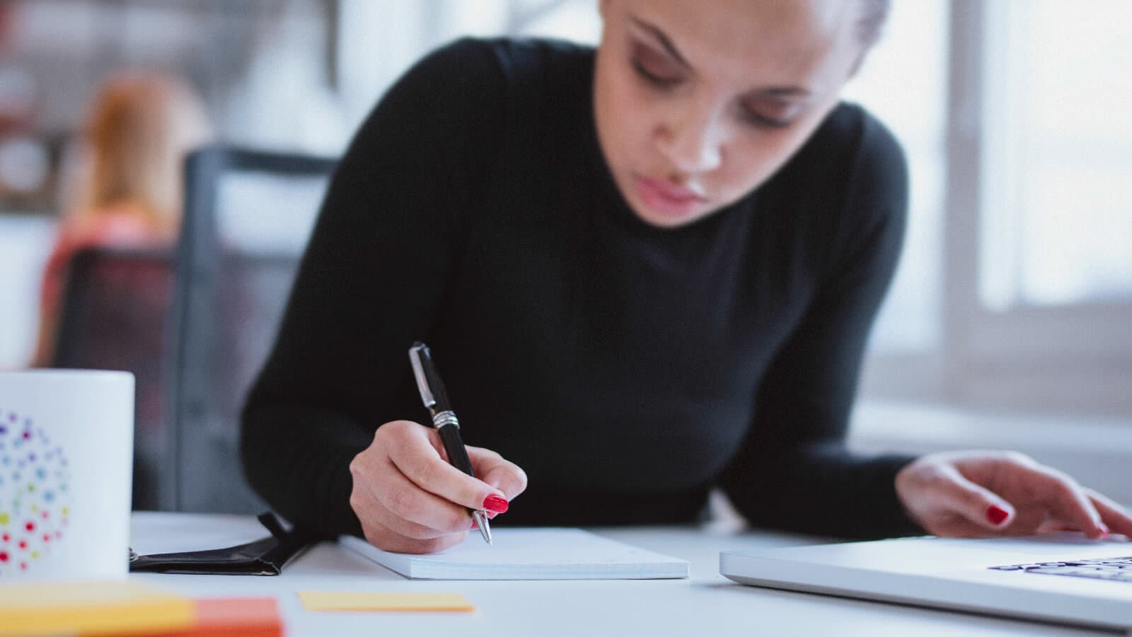 Woman writing on note pad