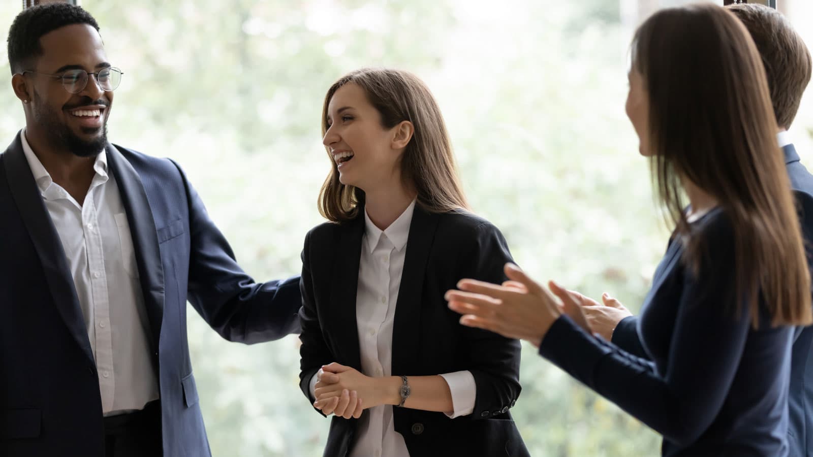 Group of 4 people, 3 are clapping