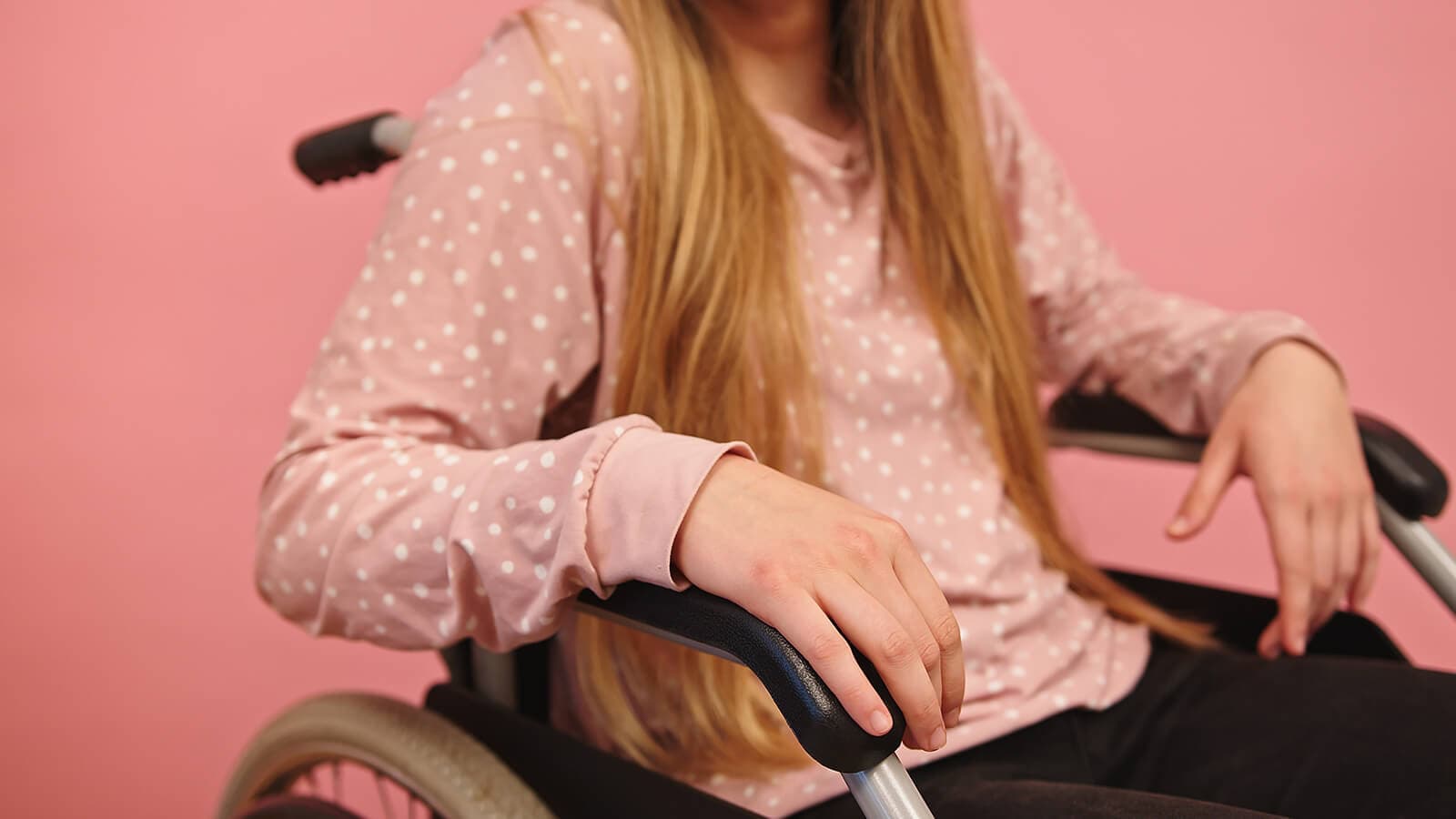 girl in pink sweater in wheelchair