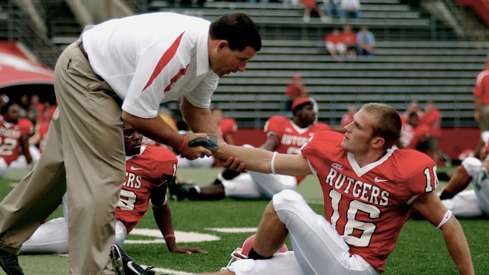 Football coach helping a player