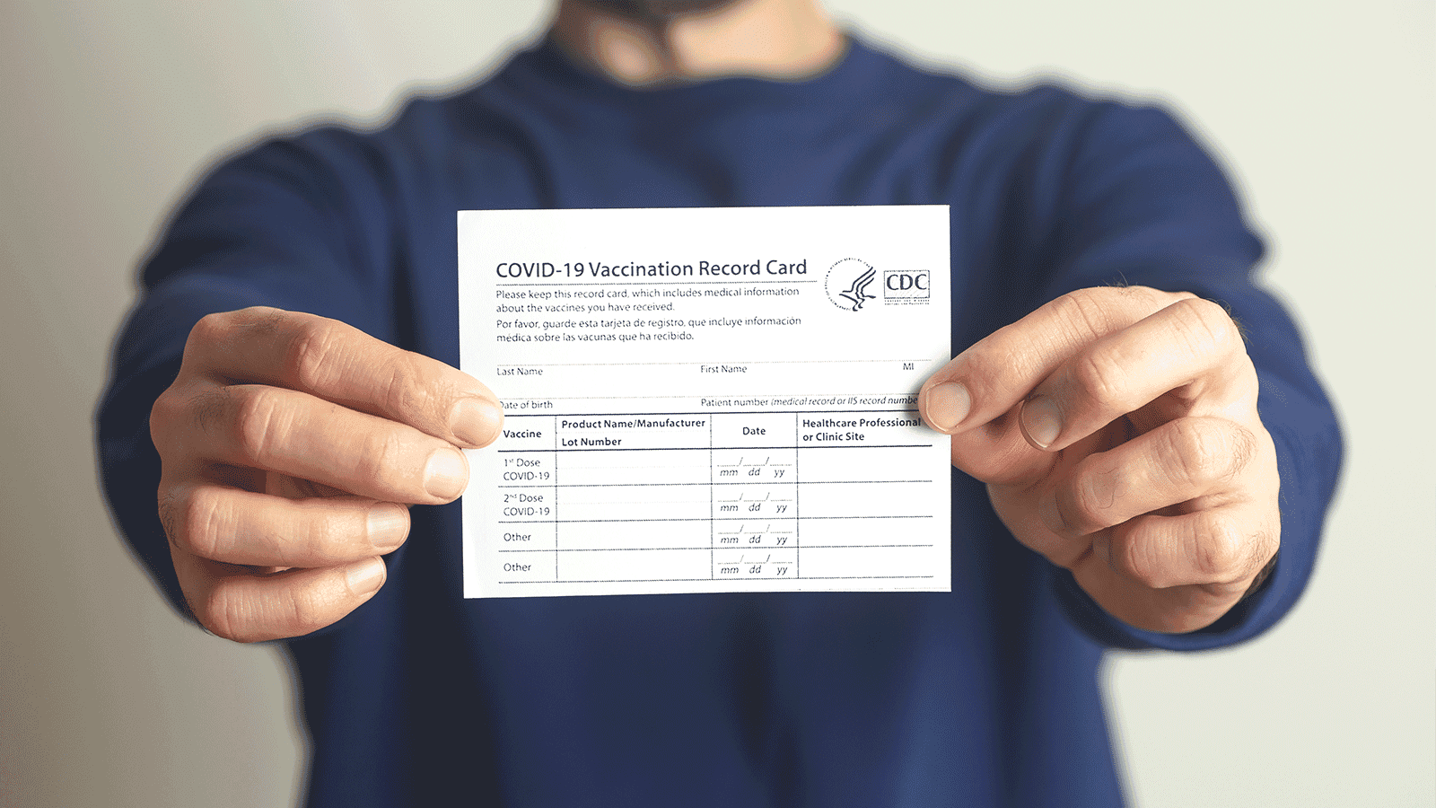 Holding COVID-19 vaccine card