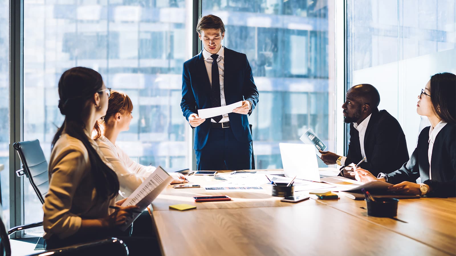 Man in suit in meeting room with bosses