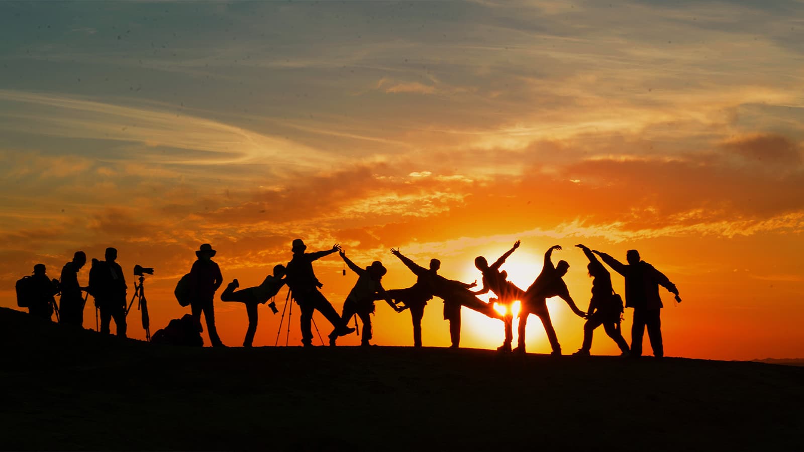 Human silhouettes in crazy positions with sunset