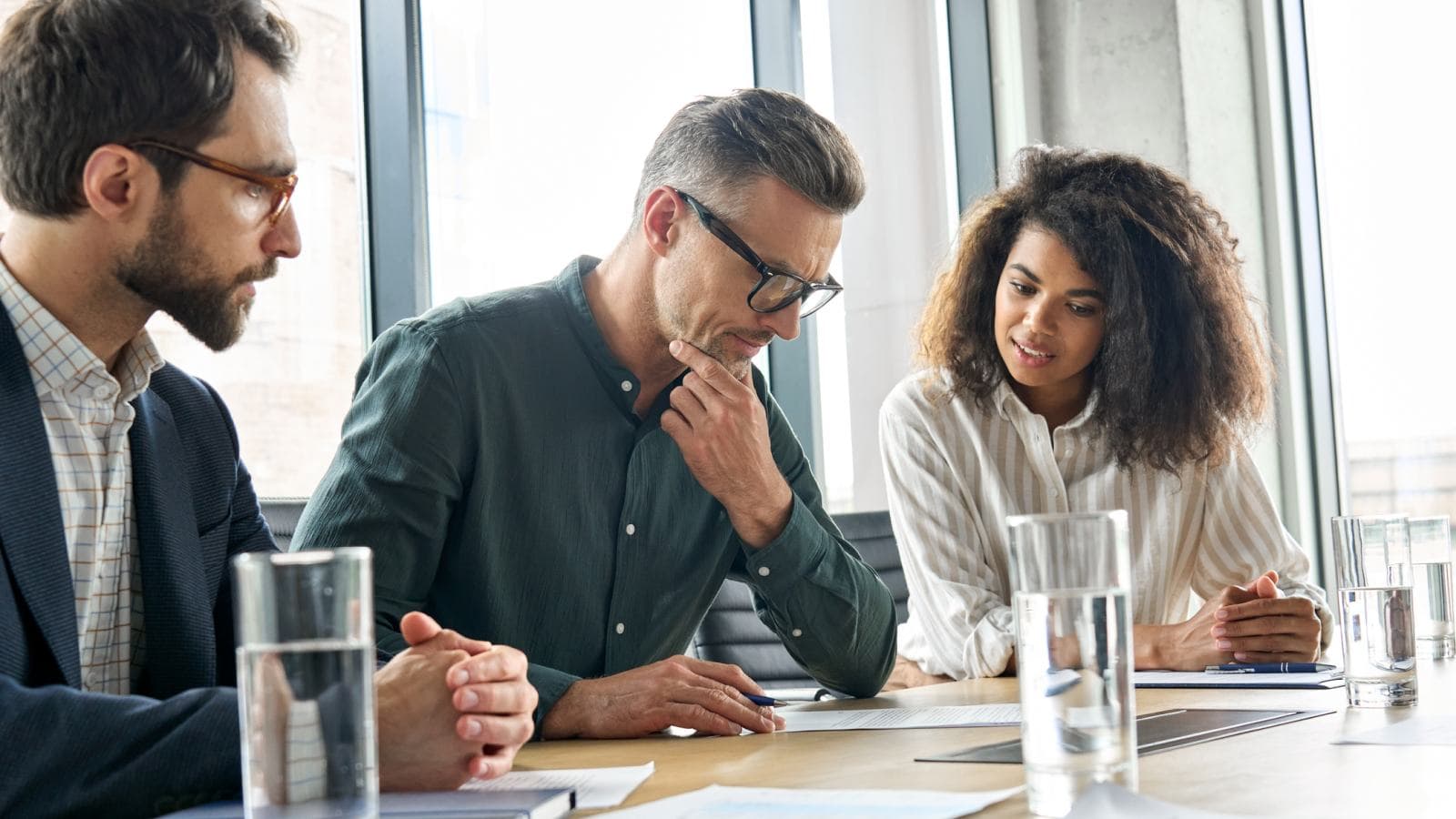 Three people sitting in a line at a desk