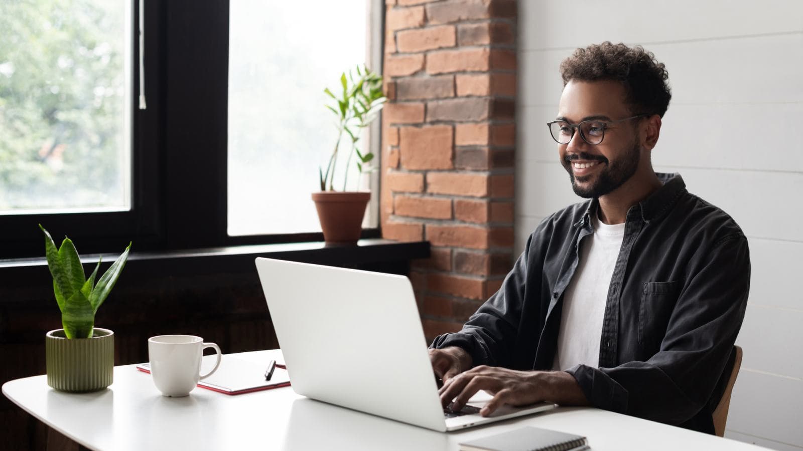 Man smiling at laptop screen