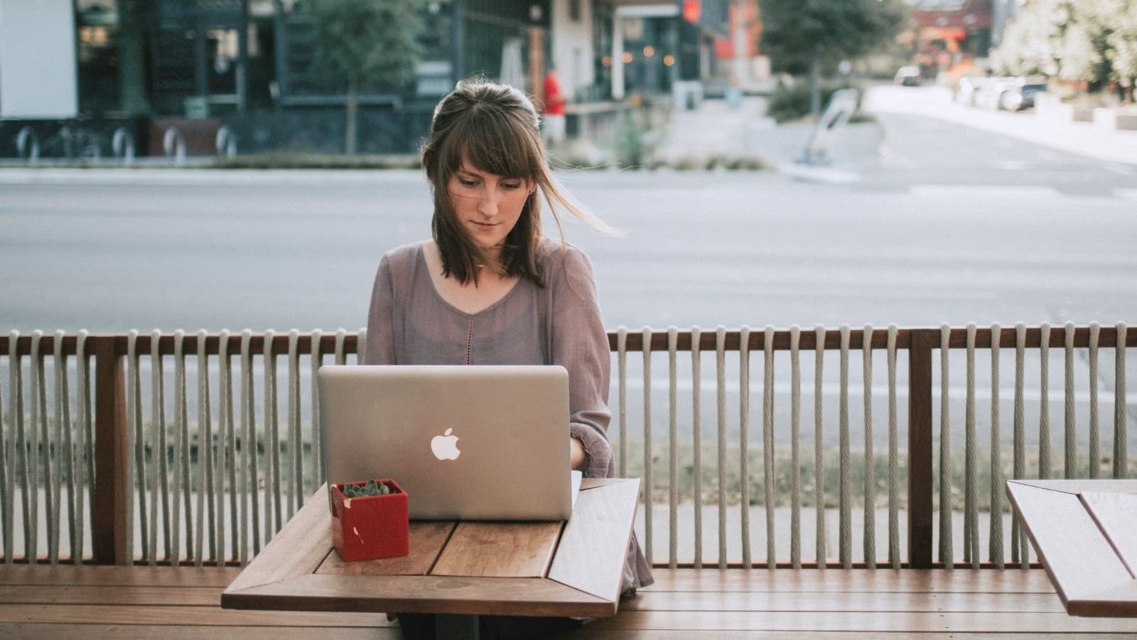 Woman working on a laptop outside on a patio