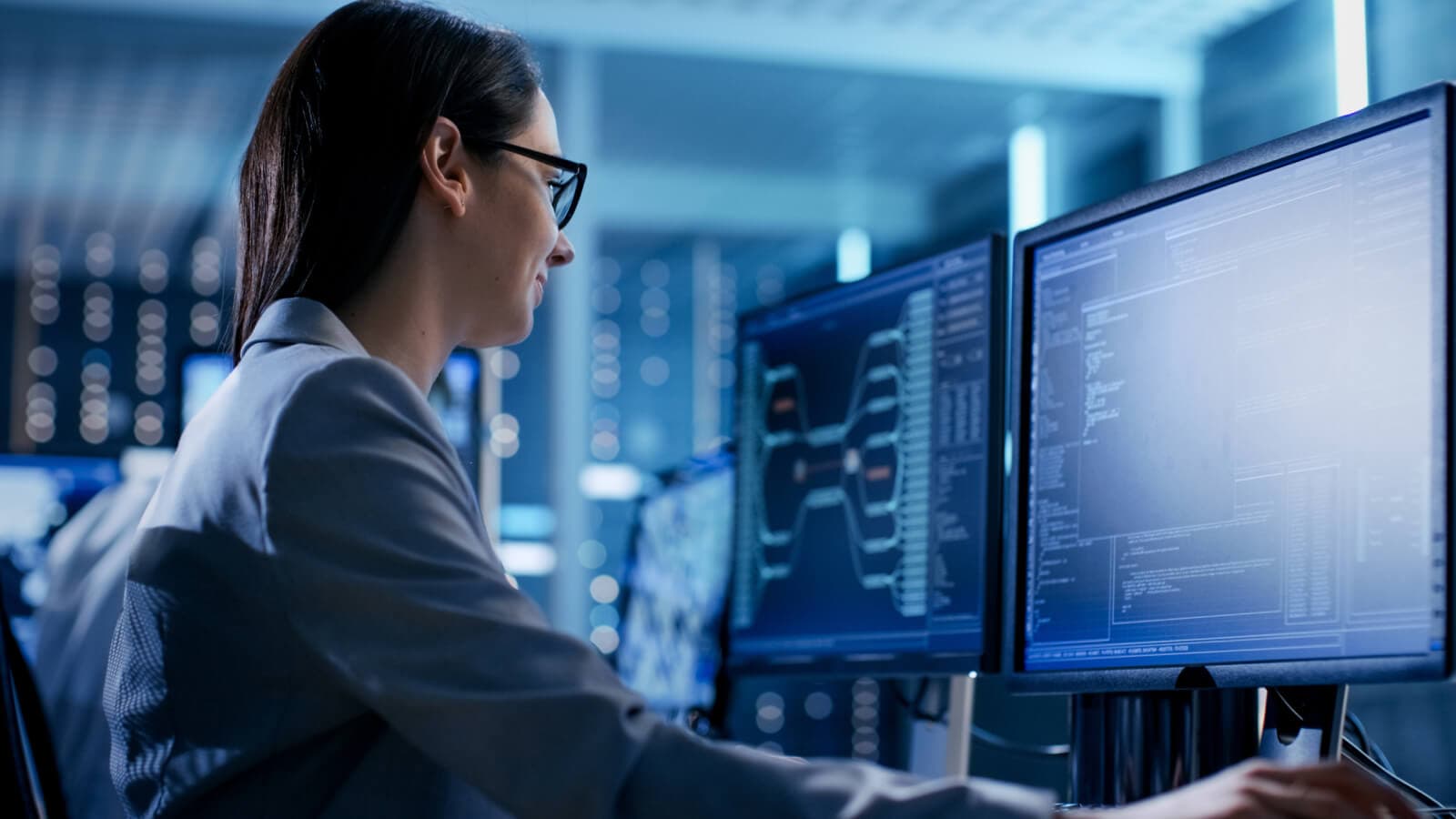 Woman looking at two screens with blue text